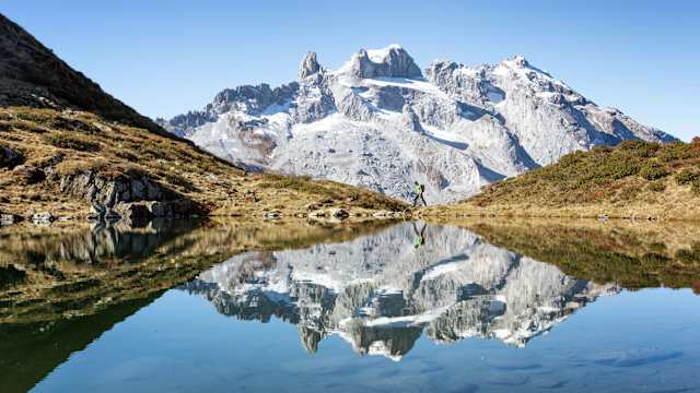 Ein Wanderer vor einem verschneiten Gebirge