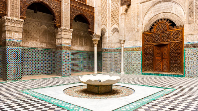 Innenhof mit Mosaik an den Wänden und dem Boden in Fes, Marokko.