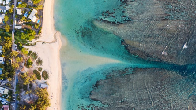 Ein Strand mit hellem Sand und türkisem Wasser