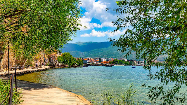 Uferpromenade am Ohridsee. Im HIntergrund ist eine Stadt zu sehen.