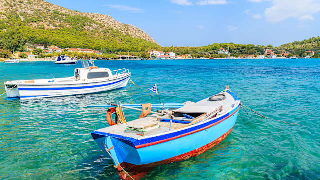 Griechischen Angelboote/Fischerboote auf dem türkisfarbenen Meerwasser in Posidonio Bucht, Insel Samos, Griechenland