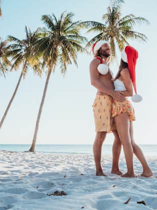 Glückliches Paar am tropischen Strand zu Weihnachten ©iStock.com/Mystockimages