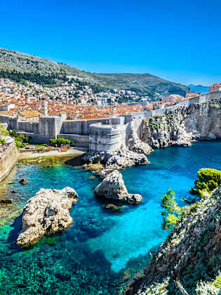 Blick auf die Stadt Dubrovnik mit ihrer Stadtmauer auf der Felsküste © iStock.com/Dreamer4787