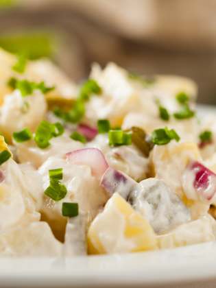 Eine Schüssel voller deutscher Kartoffelsalat mit Mayonnaise.