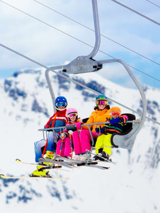 Familie im Skilift in den Bergen ©iStock.com/FamVeld