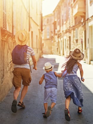 Familie mit zwei Kindern rennt durch die Altstadt von Mallorca © iStock.com/Imgorthand