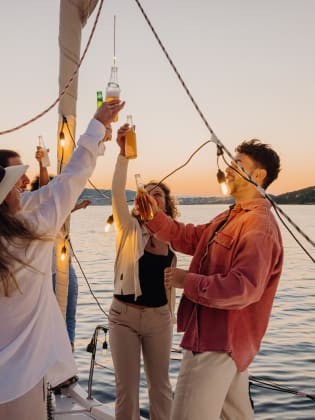 Freunde gemeinsam bei einer Bootsparty in Kroatien. © SimonSkafar/E+ via Getty Images