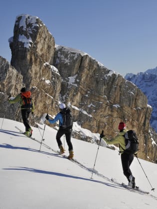 Gruppe von Personen läuft Ski in den Dolomiten © iStock.com/Gorfer