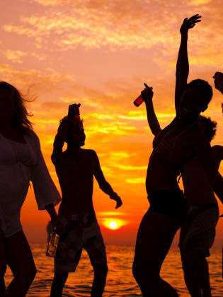 Gruppe beim Tanzen bei Sonnenuntergang