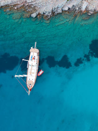 Luftaufnahme von einem Segelschiff in türkisfarbenem Meer © iStock.com/bodrumsurf