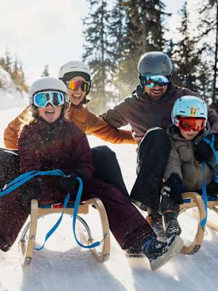 Bild von Familie auf Schlitten.
