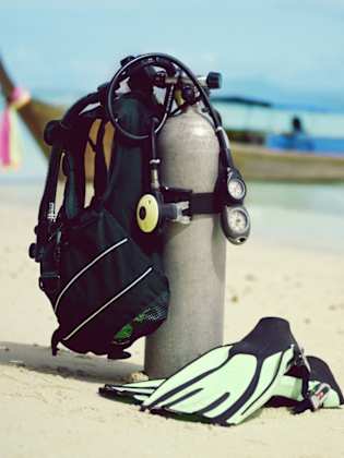 Scuba tank und Flossen am Strand © iStock.com/Image Source