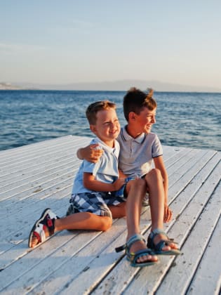 Zwei Brüder sitzen im Türkei Resort am Pier am Mittelmeer ©iStock.com/ASphotowed