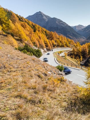 Autos fahren über eine gewundene Straße über den Albula Pass in der Schweiz.
