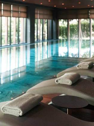 Ein Indoorpool mit gemütlichen Liegen.