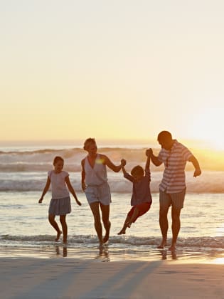 Eine Familie beim Sonnenuntergang am Strand.