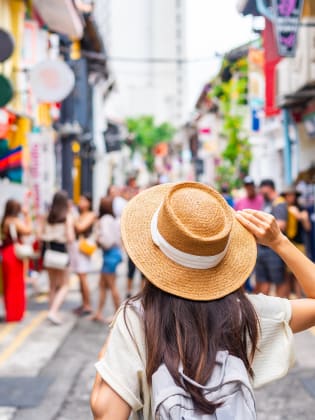 Eine Touristin läuft alleine durch eine Einkaufsstraße in Singapur.