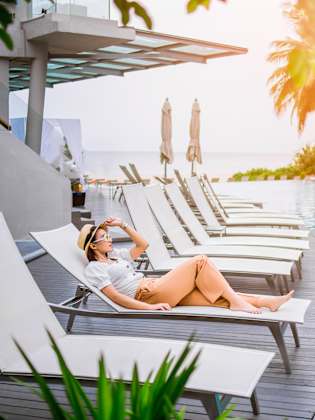 Frau in einem Liegestuhl am Pool