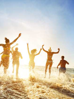 Partyfreunde im Sonnenuntergang am Strand