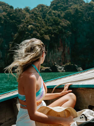 Eine junge Frau sitzt im thailändischen Boot auf dem Weg nach Krabi, Thailand.