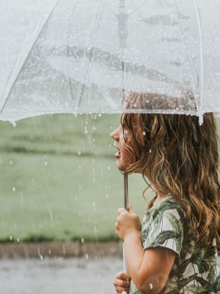 Mädchen hält ein Regenschirm.
