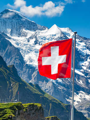 Berg mit Schweizer Fahne im Vordergrund