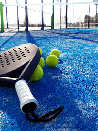 Ein Paddle Schläger liegt auf dem Boden eines Platzes