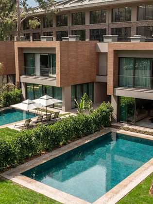 Mehrere Privatvillen nebeneinander mit Privatpool und Liegen