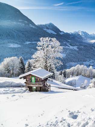 Panoramablick auf die Bergwelt mit einer Hütte in den Alpen.