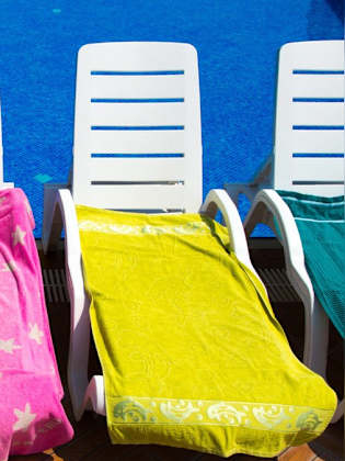 Poolliegen mit Handtüchern zu reservieren ist für viele eine Unsitte. © Naked King/iStock via Getty Images