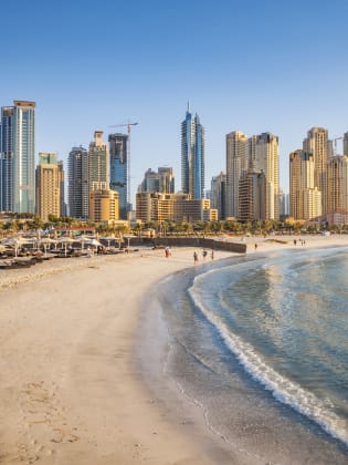 Strand mit Skyline im Hintergrund in Dubai, Vereinigte Arabische Emirate © Marcutti/Moment via Getty Images