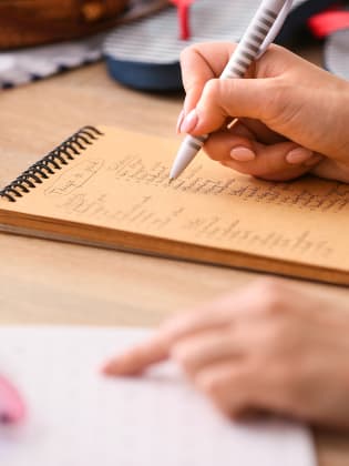 Frau hakt Checkliste für Sommerurlaub ab.