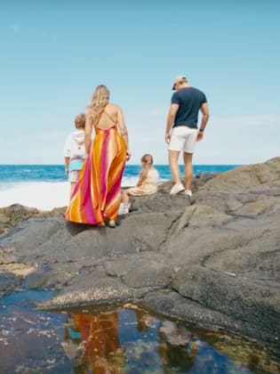 Mutter, Vater und zwei Kinder an einem steinigen Strand auf Fuerteventura, Kanaren.