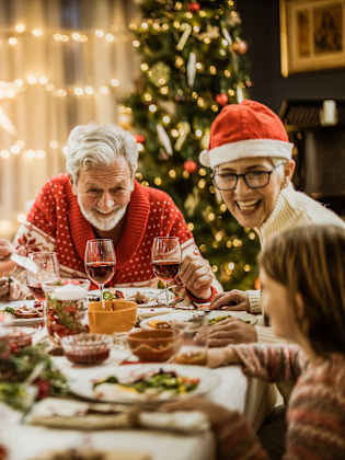 Familie sitzt Weihnachten gemeinsam am Tisch