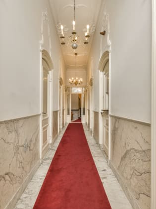Hotelflur mit rotem Teppich und weißen Wänden