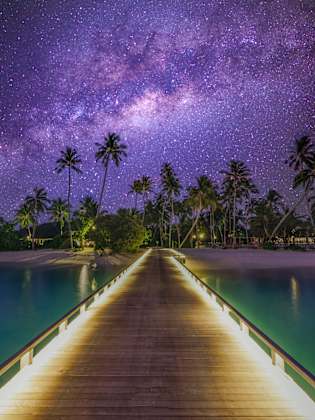 Sternenhimmel am Pier am Meer mit Palmenstrand.