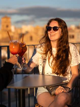 Zwei Frauen stoßen mit einem Aperol an