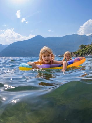 Kinder schwimmen im Lago Maggiore