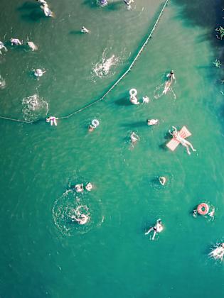 Menschen im See mit Luftmatratzen