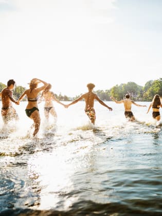Freunde laufen in einen Badesee