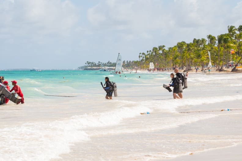 Eine Gruppe von Menschen, die zum Tauchen ins Meer gehen © iStock.com/ico_k-pax