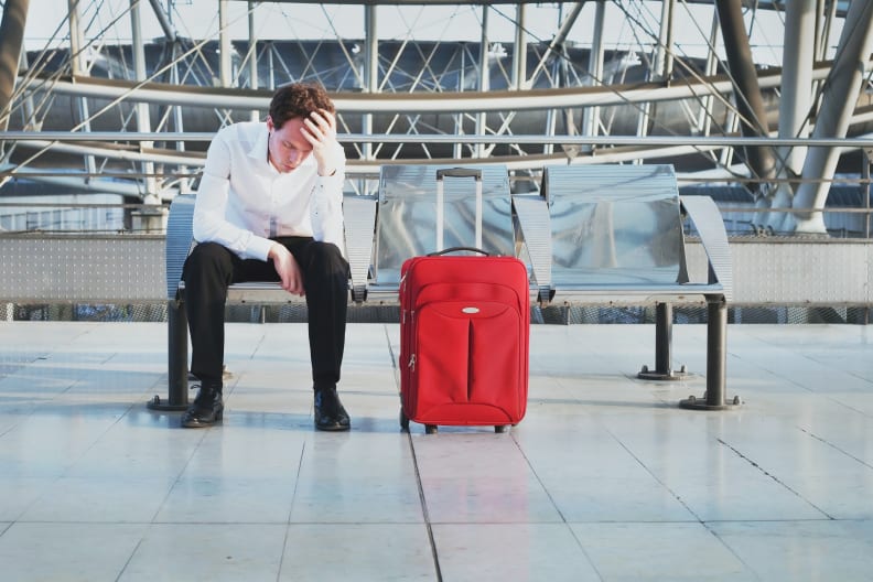 Wegen Flugverspätung oder Problem auf dem Flughafen wartet ein müder Passagier am Terminal ©iStock.com/anyaberkut