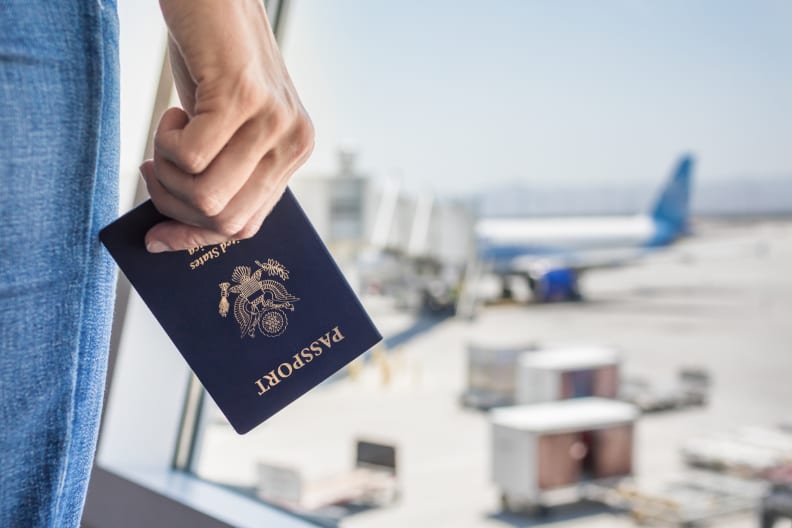 Frau wartet mit Reisepass am Flughafen © iStock.com/kieferpix