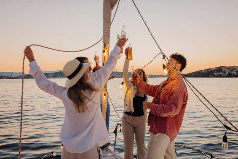 Freunde gemeinsam bei einer Bootsparty in Kroatien. © SimonSkafar/E+ via Getty Images