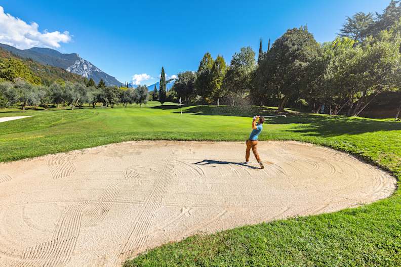 Ein Mann beim Abschlag aus einer Sandgrube