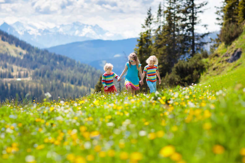 Kleiner Junge und Mädchen auf Wanderweg in blühender Almwiese © iStock.com/FamVeld