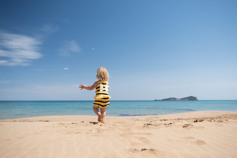 Kleines Mädchen rennt glücklich über einen Sandstrand im Urlaub © iStock.com/kamsta