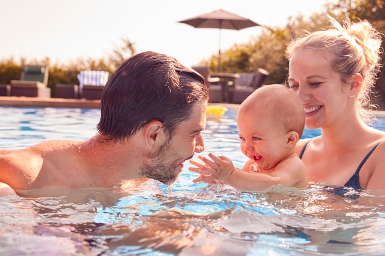 Mutter und Vater haben Spaß mit Baby im Pool © iStock.com/monkeybusinessimages