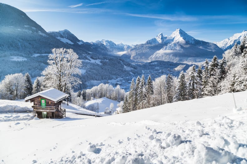 Panoramablick auf die wunderschöne Winterwunderland Bergwelt mit einer Hütte in den Alpen © iStock.com/bluejayphoto