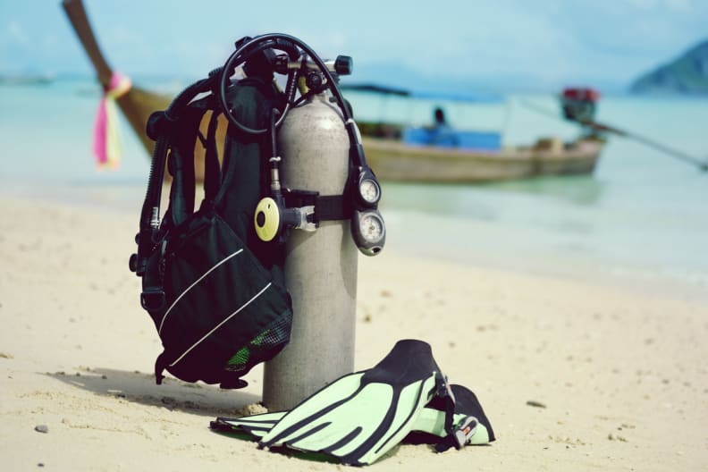 Scuba tank und Flossen am Strand © iStock.com/Image Source